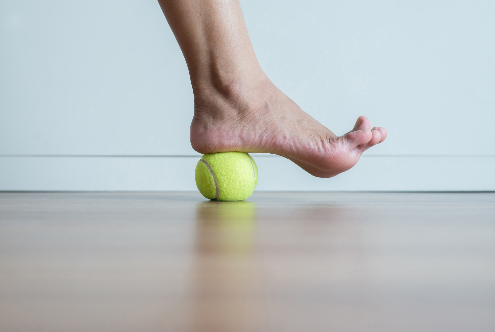 Woman massage with tennis ball to her foot in bedroom,Feet soles massage for plantar fasciitis
